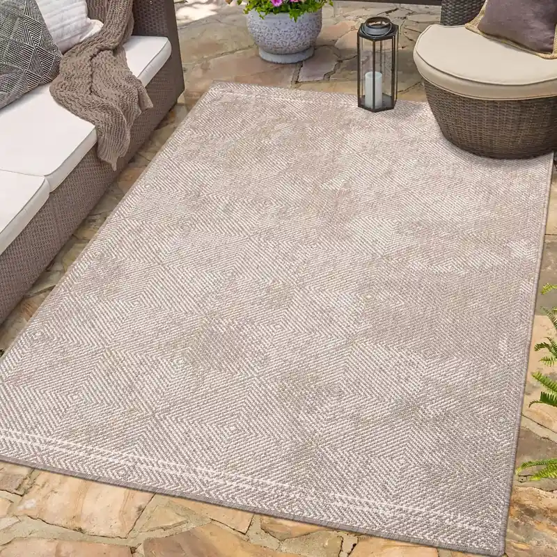 Beige geometric pattern outdoor rug on stone patio