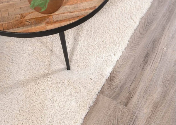 Cream-rug-under-wooden-coffee-table-on-light-wood-floor