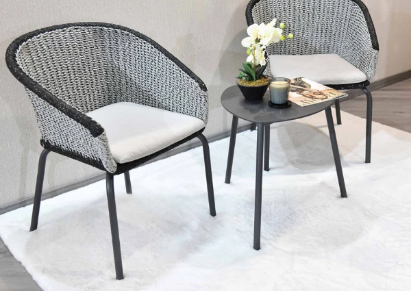 Two-grey-woven-chairs-and-small-table-set-on-a-white-rug